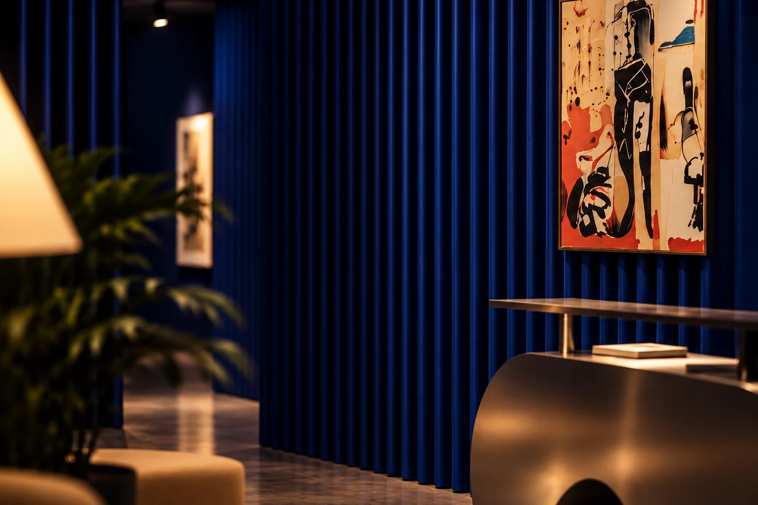 Framed abstract artwork against deep blue curtains, with warm lighting and sculptural furnishings.
